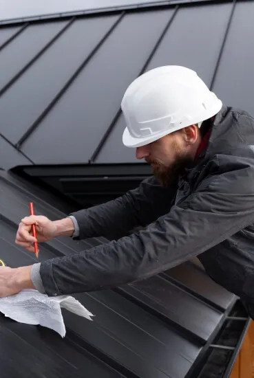 Man working on a black metal roof.